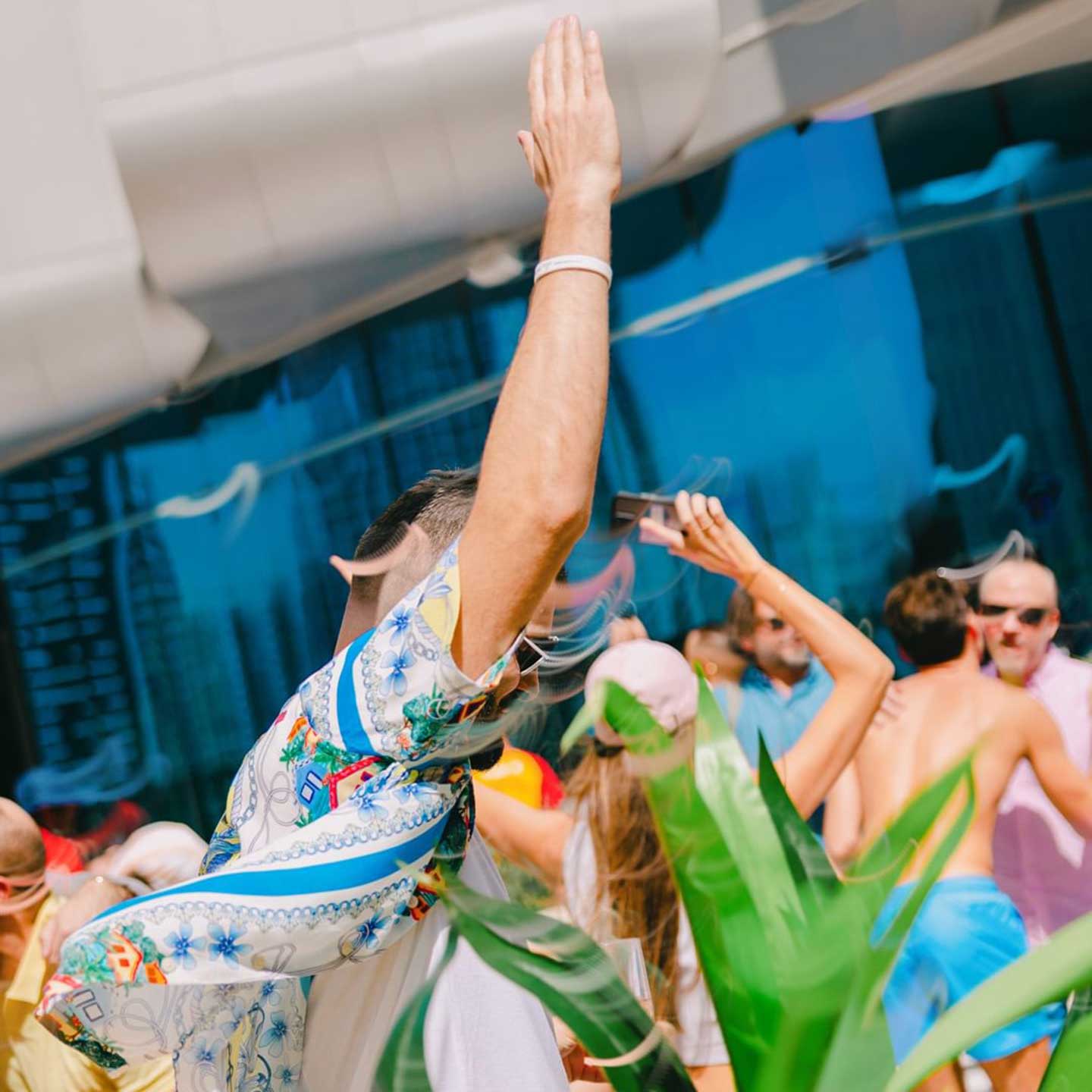 People in colourful summer clothes dancing at an outdoor party