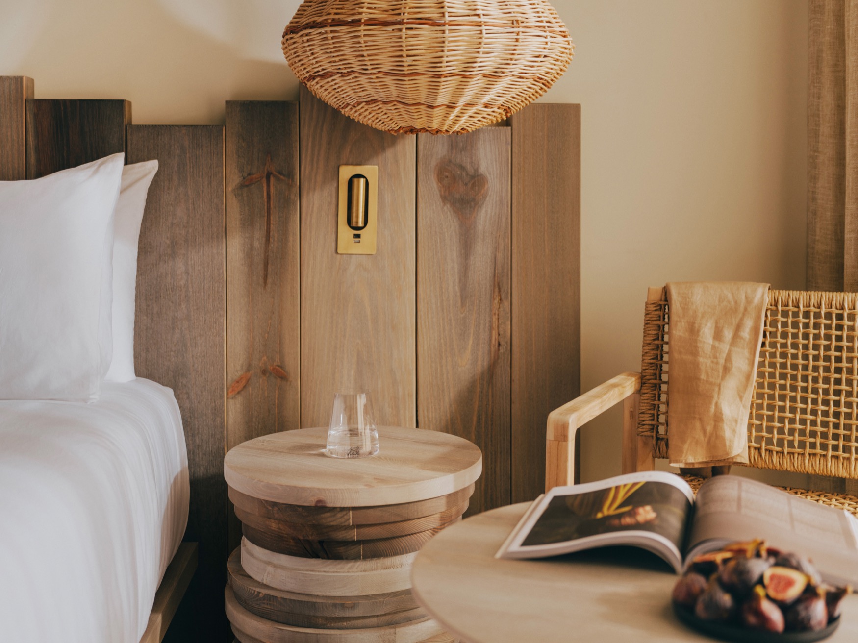 Coffee table and the arm chair next to the bedside table and a lamp hanging from the ceiling