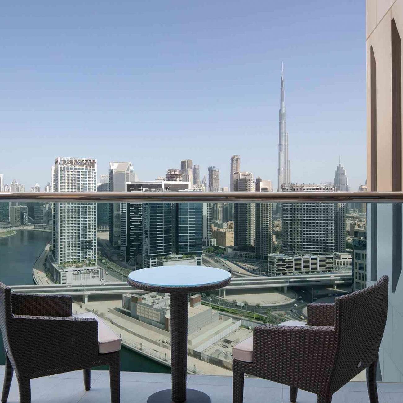 Vue du balcon d'une chambre avec 2 chaises et une table basse, avec vues sur les gratte-ciels de Dubaï et Burj Khalifa