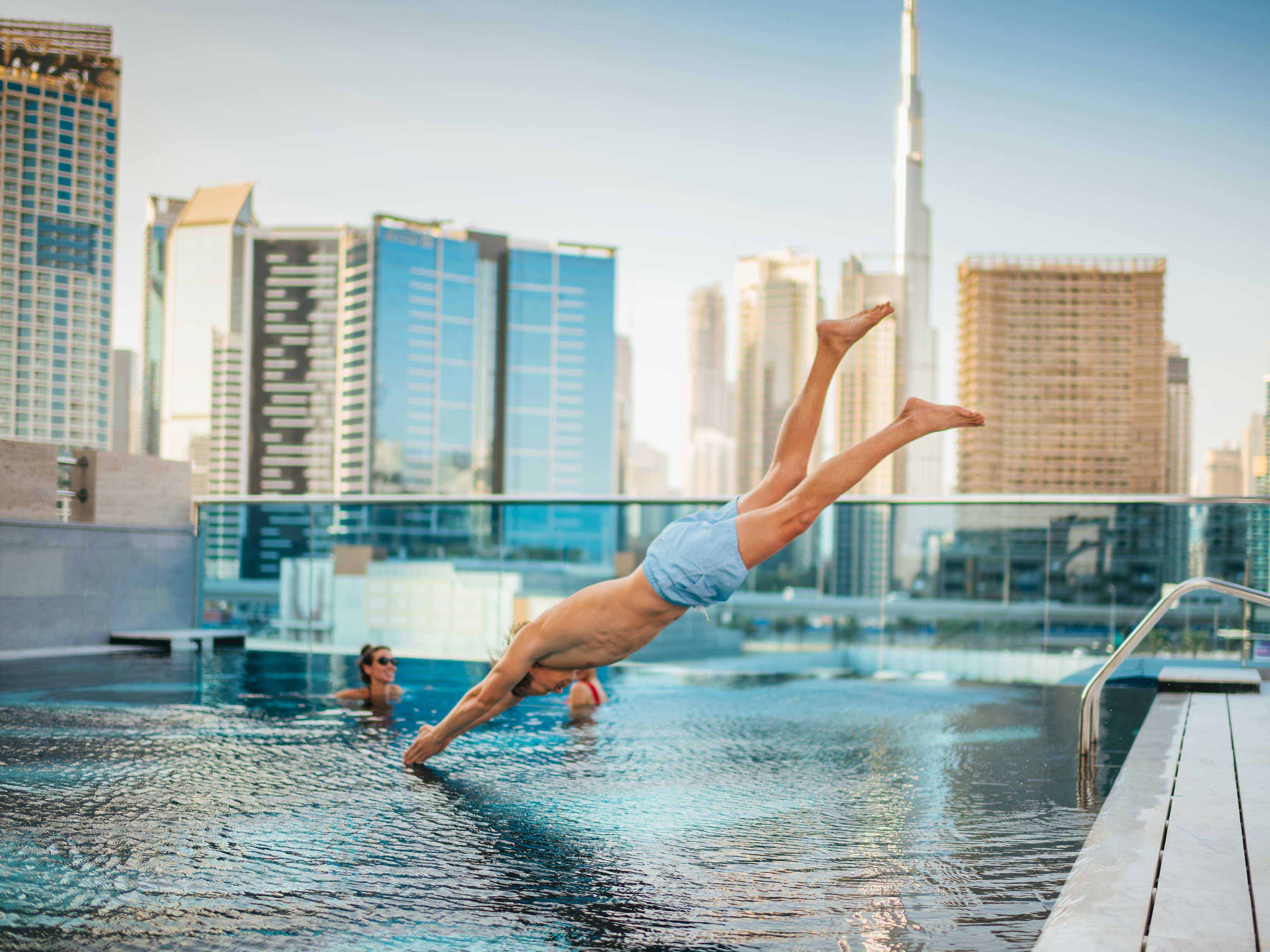 Man diving into the swimming pool at Hyde Dubai.