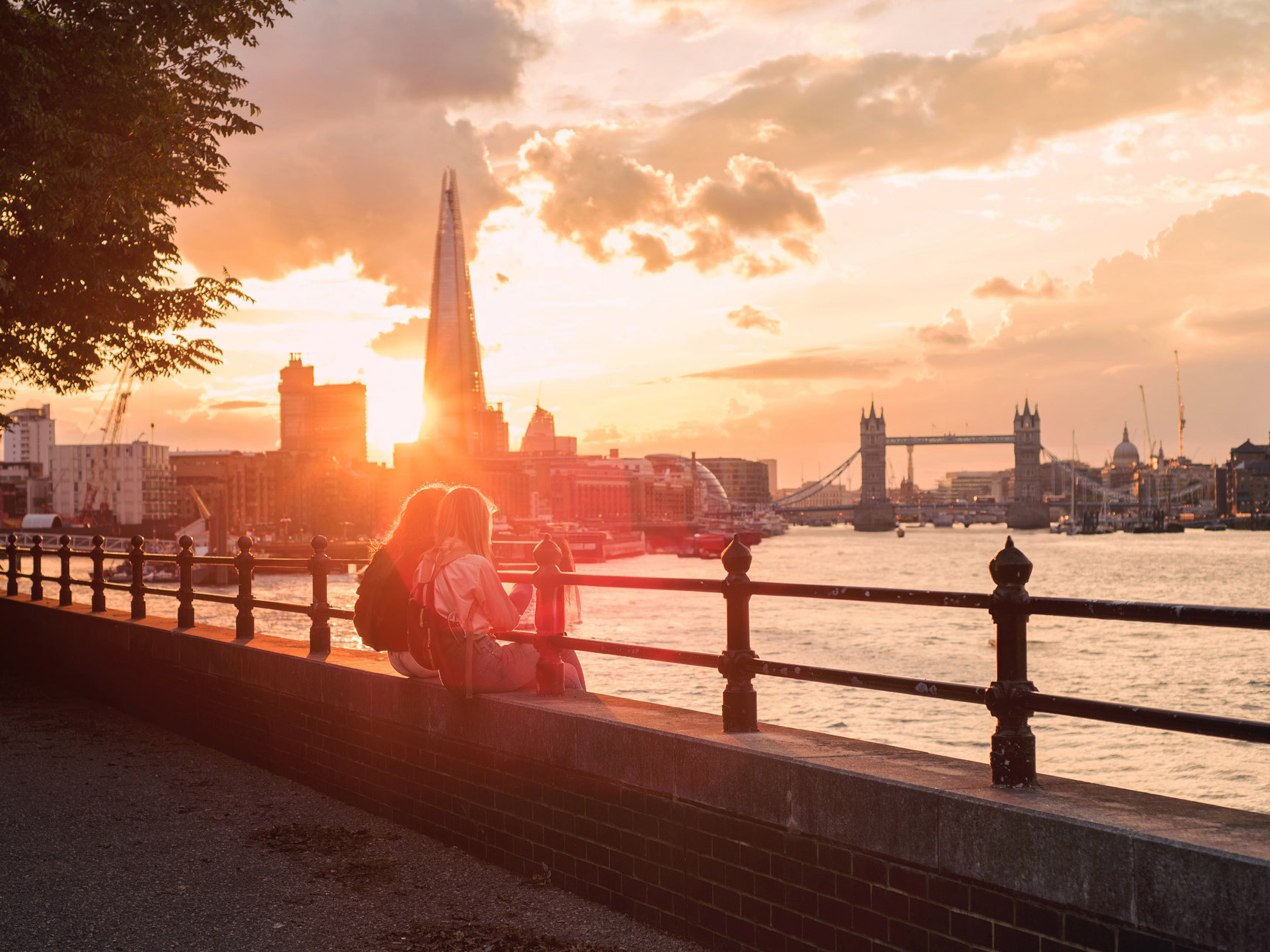 Couple sitting next to the Thames, waiting for Hyde London City to open.