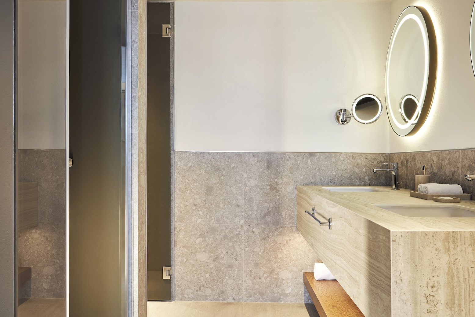 Angled view of a large bathroom sink with circular mirror above