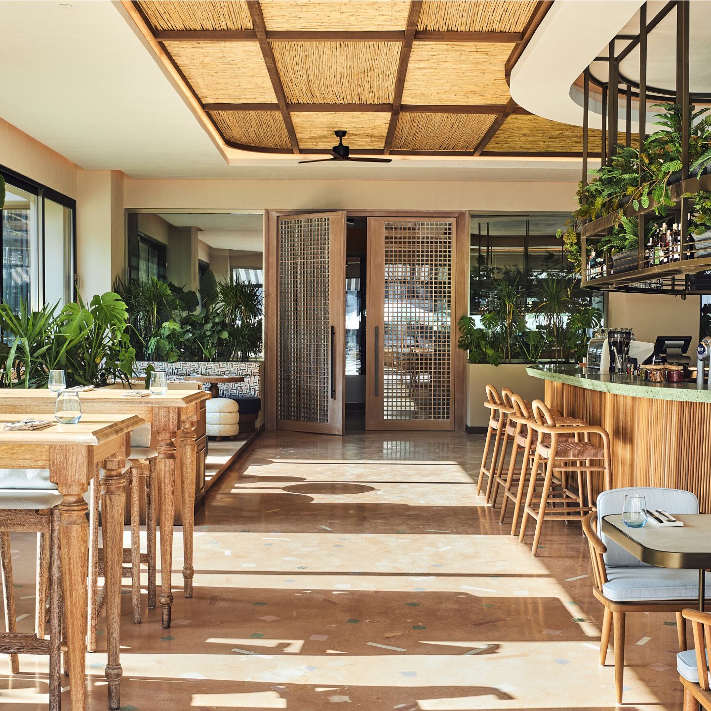 Dining room with tables and chairs on each side and large double doors in the center