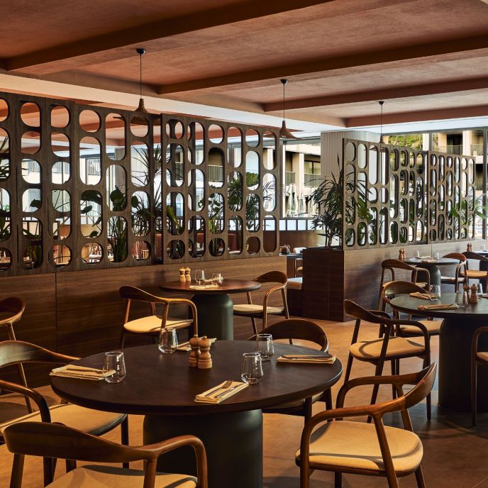Dining room with dark wooden round tables and wooden dining chairs