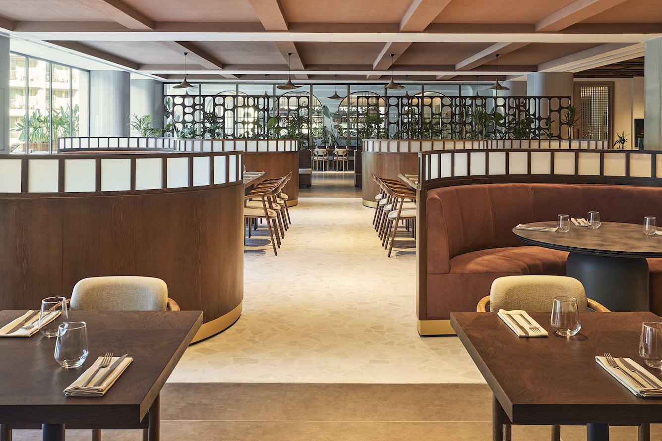Dining room with large light brown booths and wooden dining tables