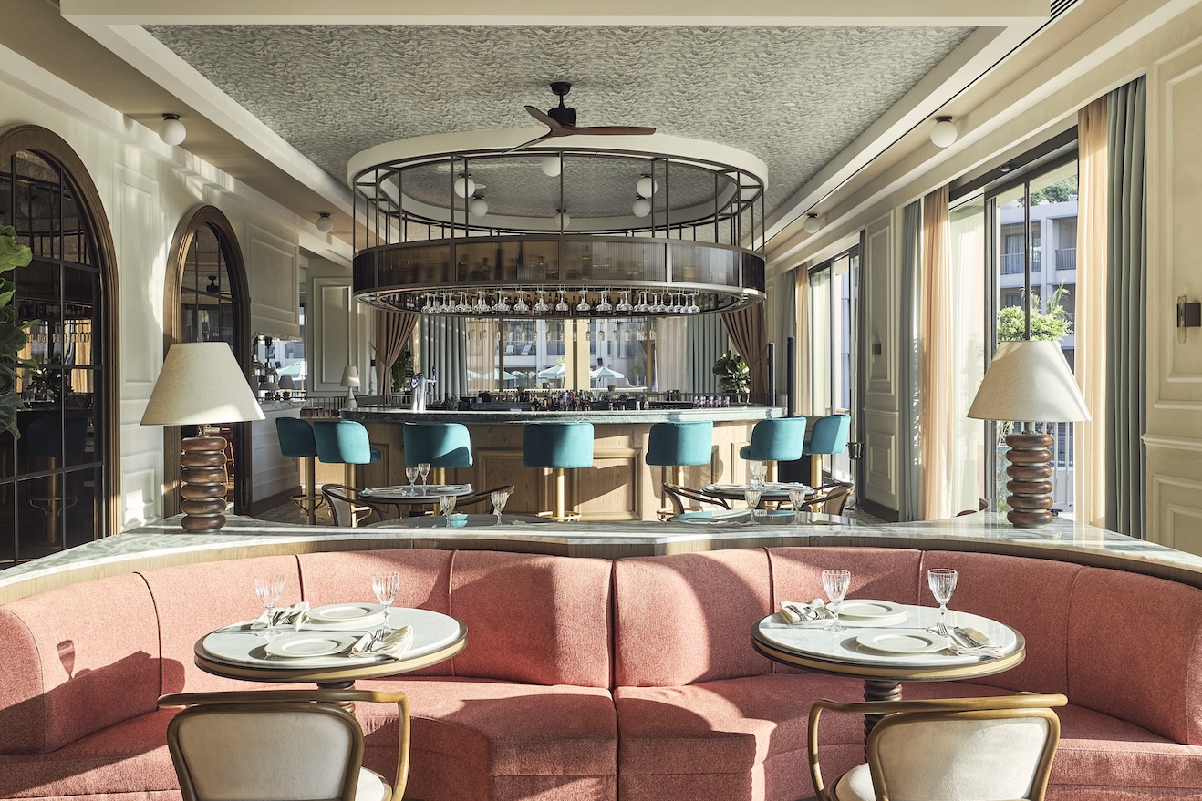 Dining room with pink velvet booth and small round tables