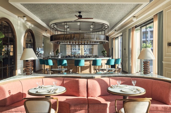 Dining room with pink velvet booth and small round tables