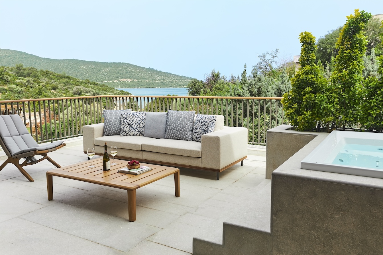 Outdoor terrace with hot tub, sofa, and coffee table