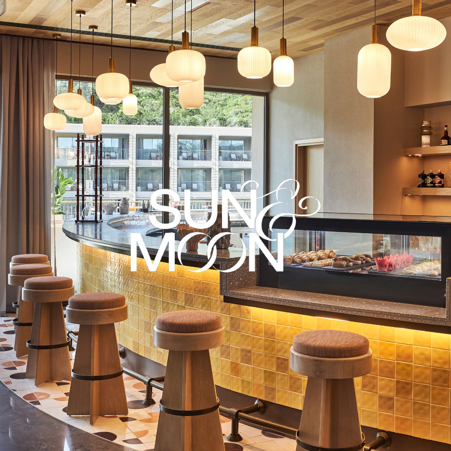 Bar with yellow tiled blacksplash, modern gold stools, and small hanging bulb lights