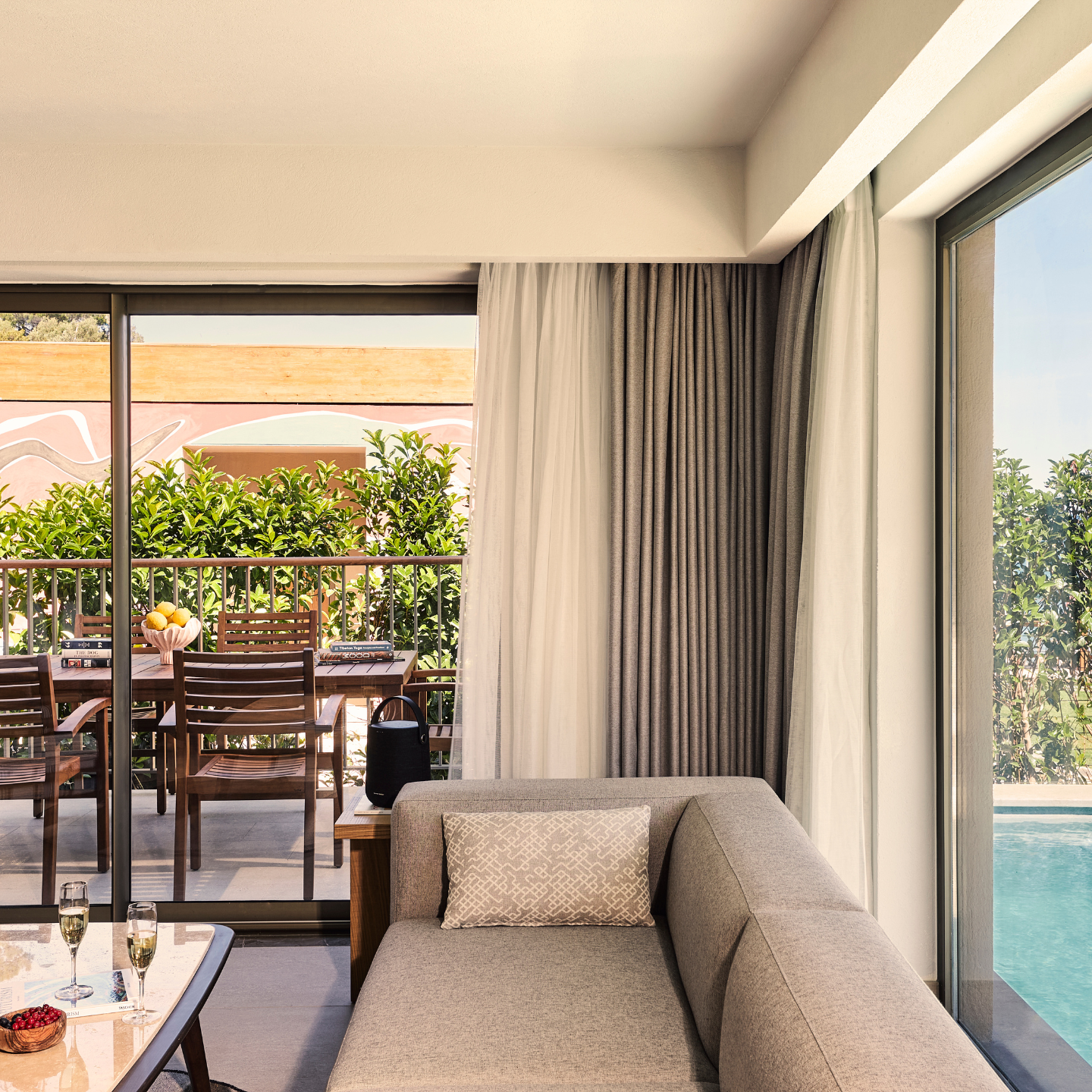 Modern, spacious hotel living room with large terrace and a pool to the side