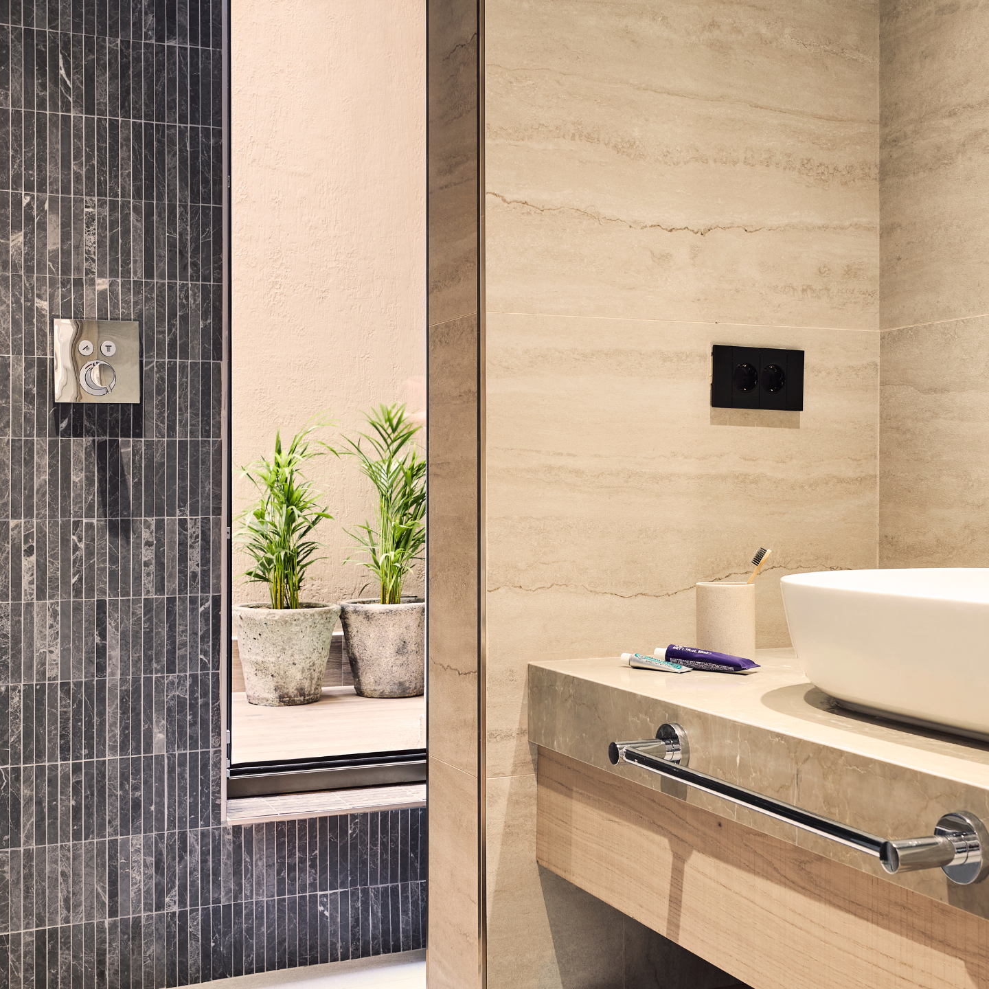 Hotel bathroom with shower, sink and plants