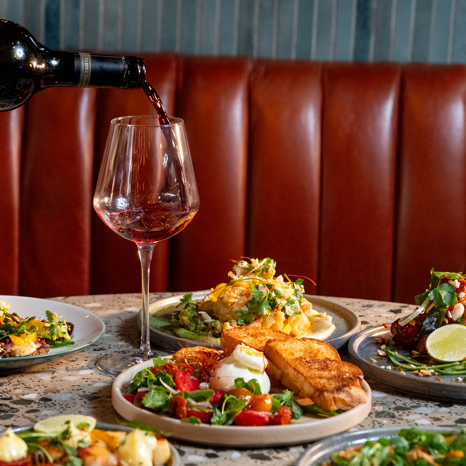 A delicious breakfast spread laid out on the table with a drink being poured.