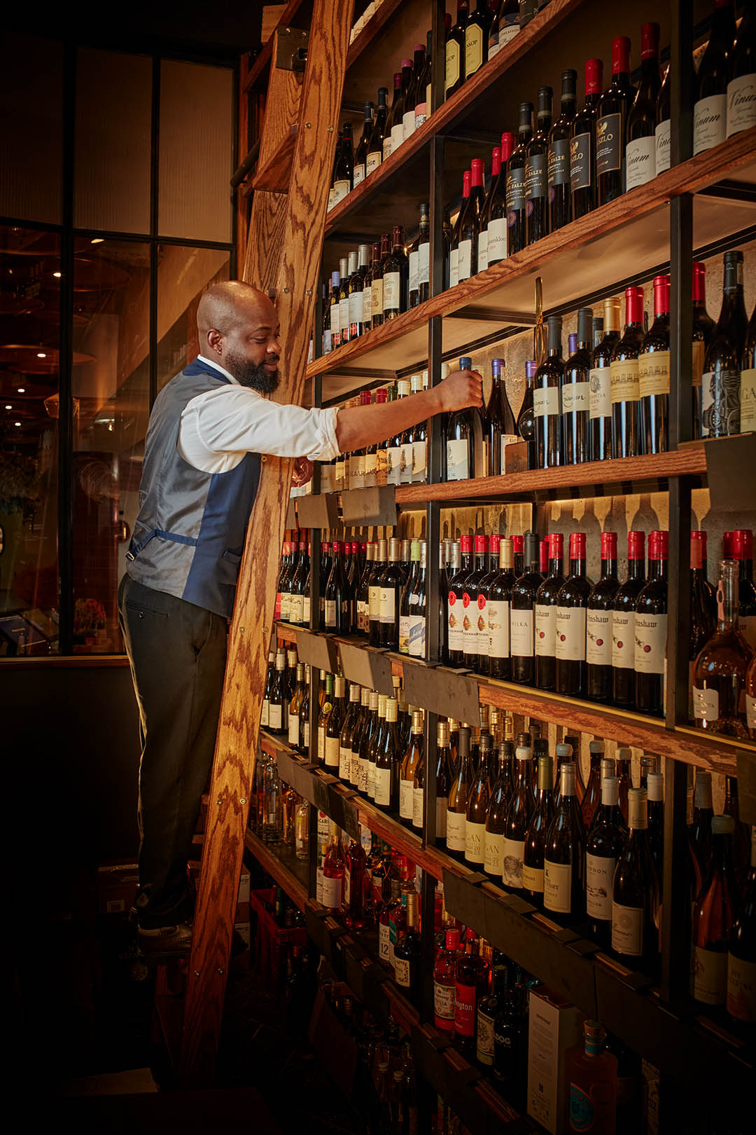 A waiter picking from Proud Mary's wine selection