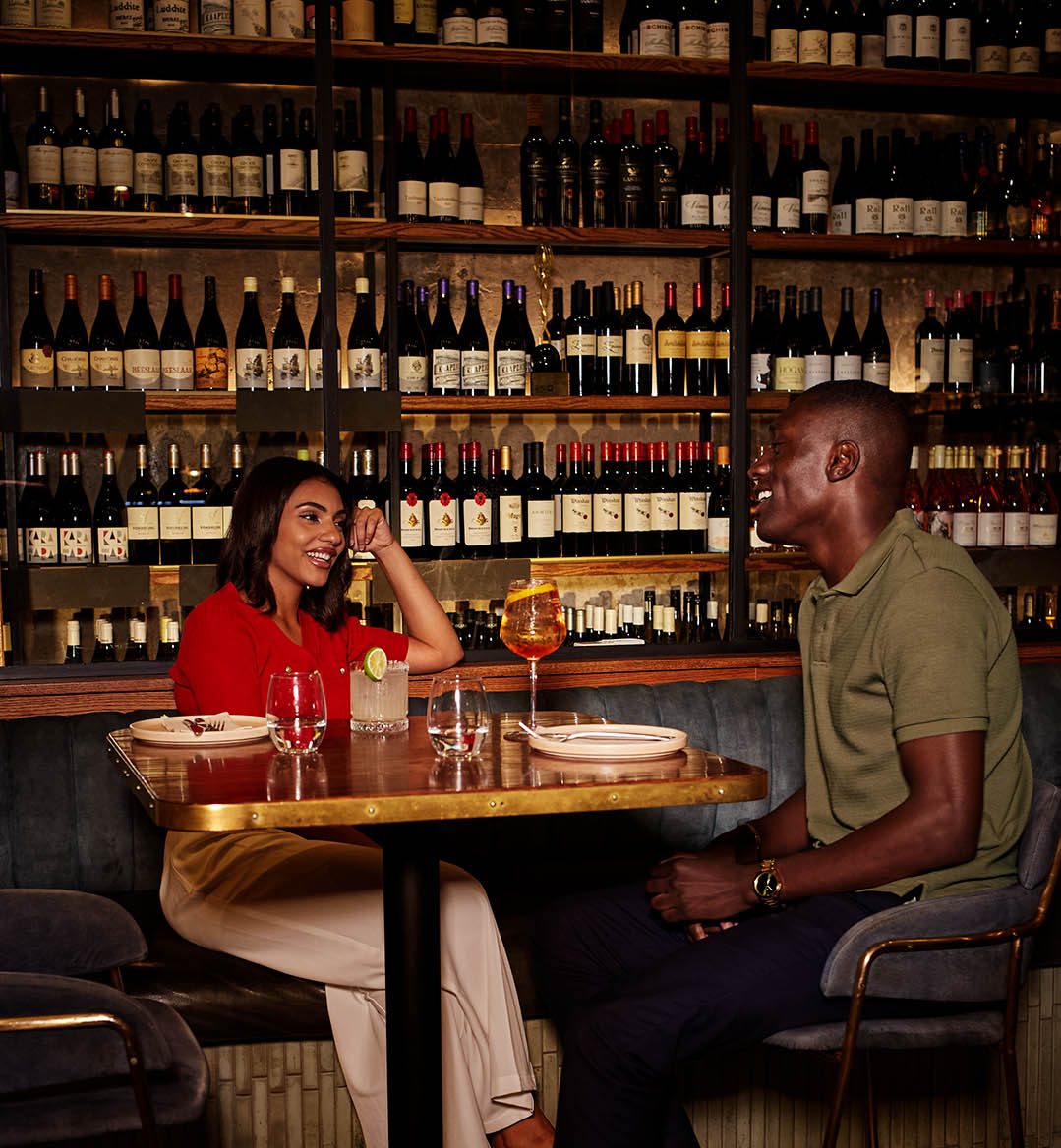 Two friends sitting and talking at Proud Mary.