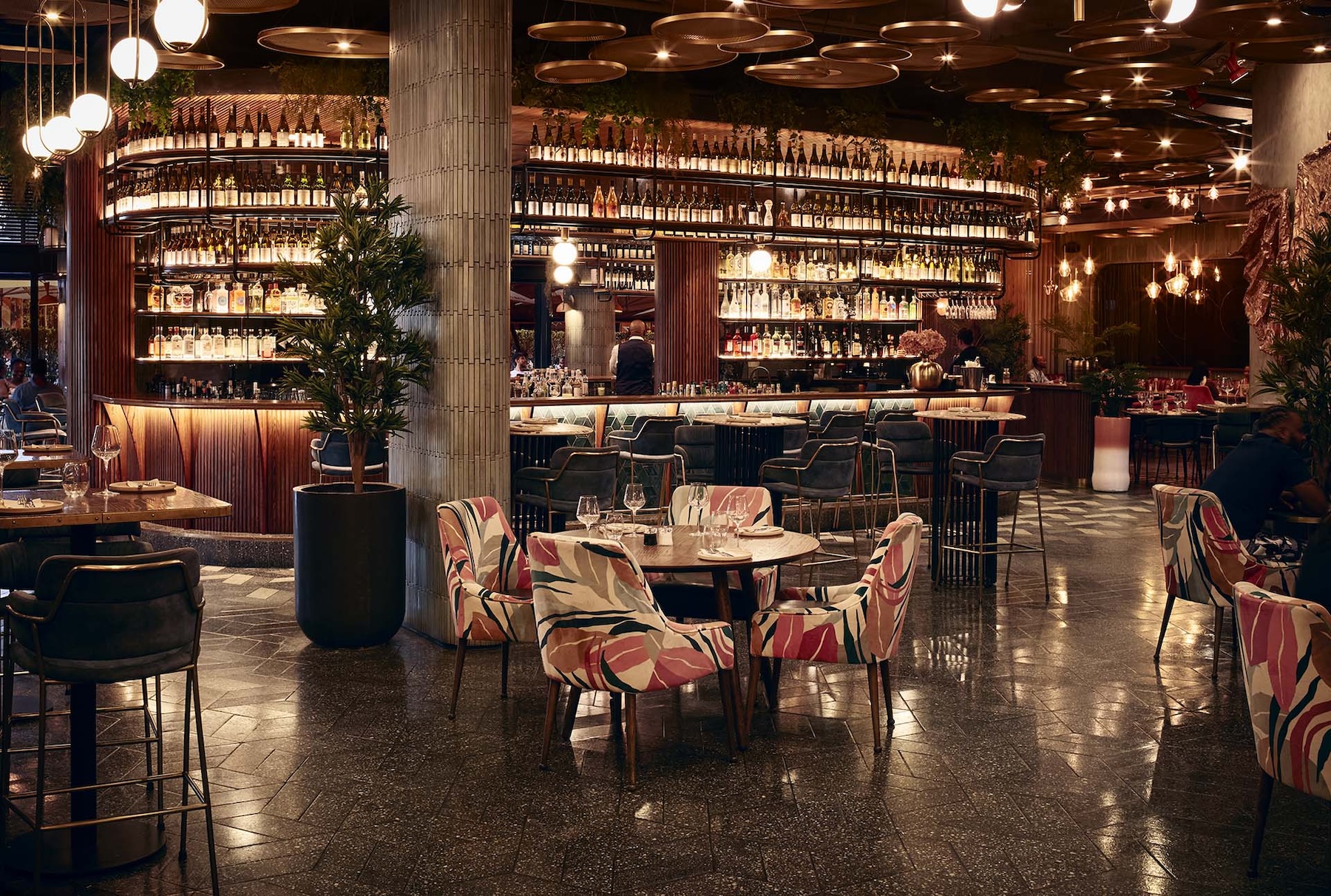 The Proud Mary setting in the night, lit brightly throughout the restaurant, with the wrap around bar in the back.