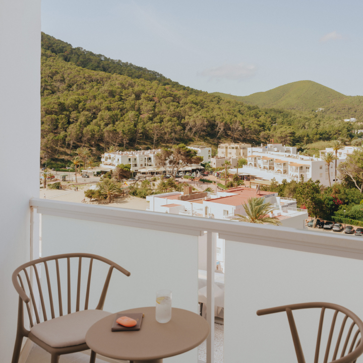 A balcony with table and chairs overlooking mountains