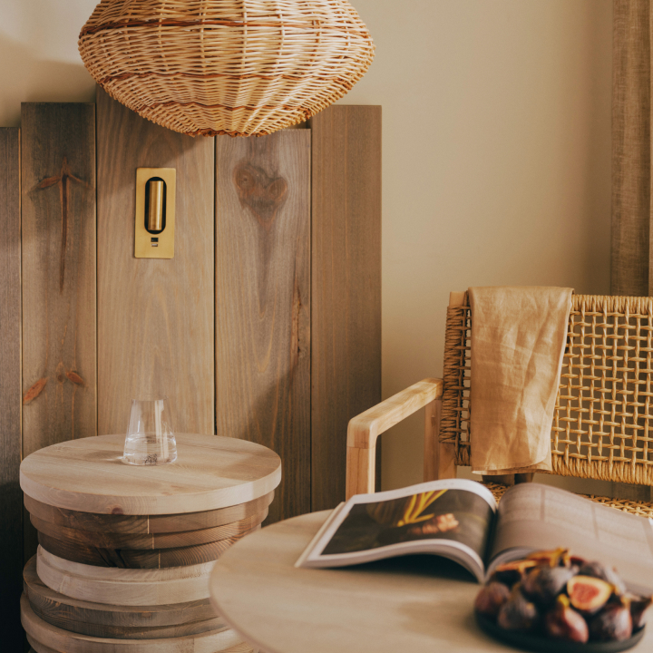A decorative light above a round table with an armchair alongside