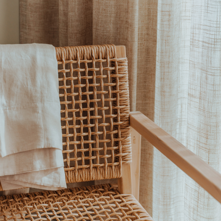 A close up of a chair with blanket hanging over it