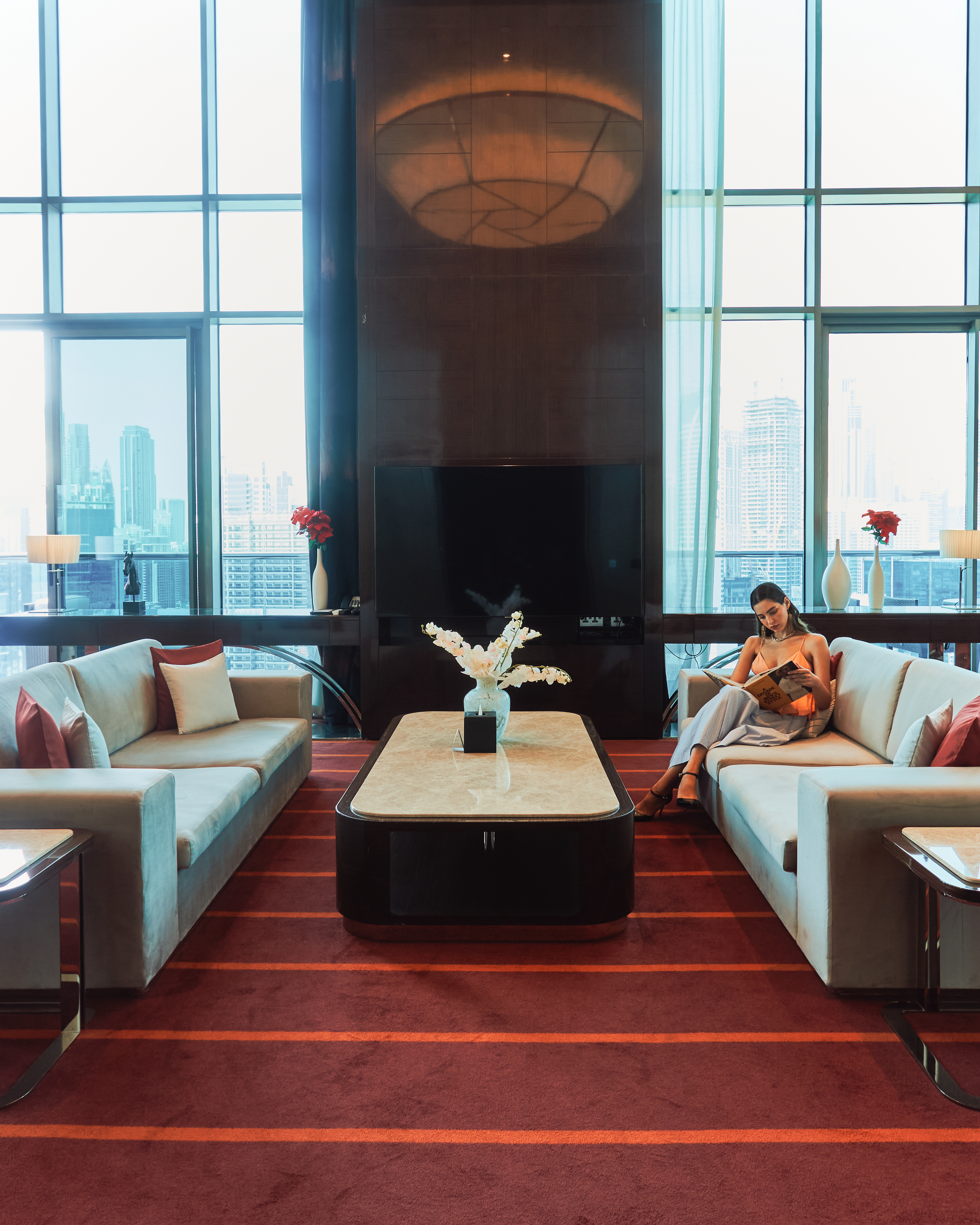 A lady in a suite sitting on a sofa