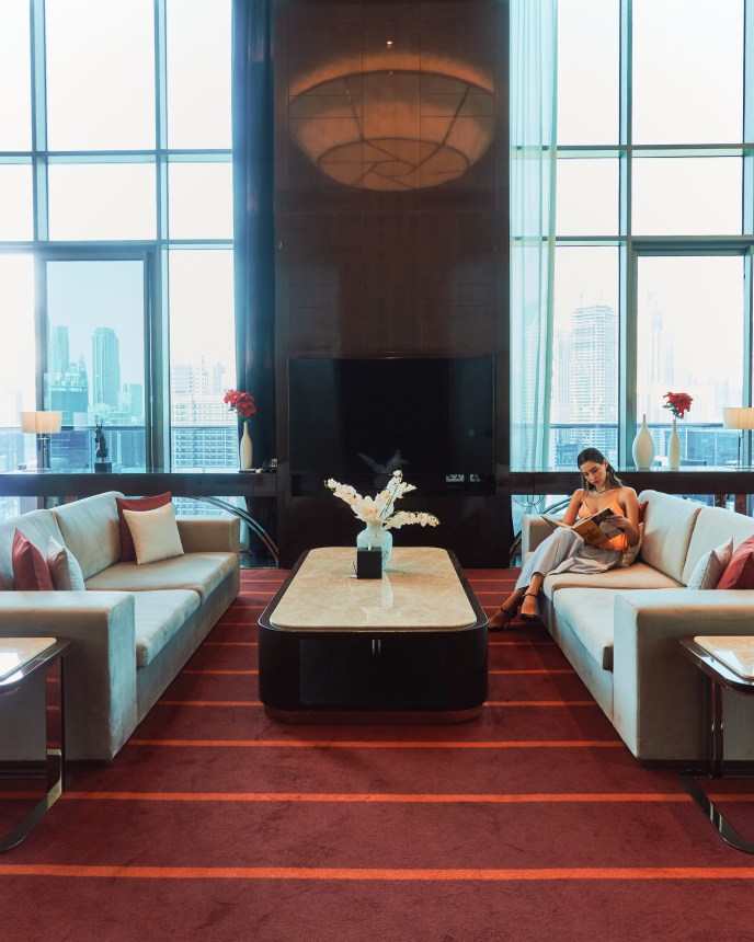 A lady in a suite sitting on a sofa